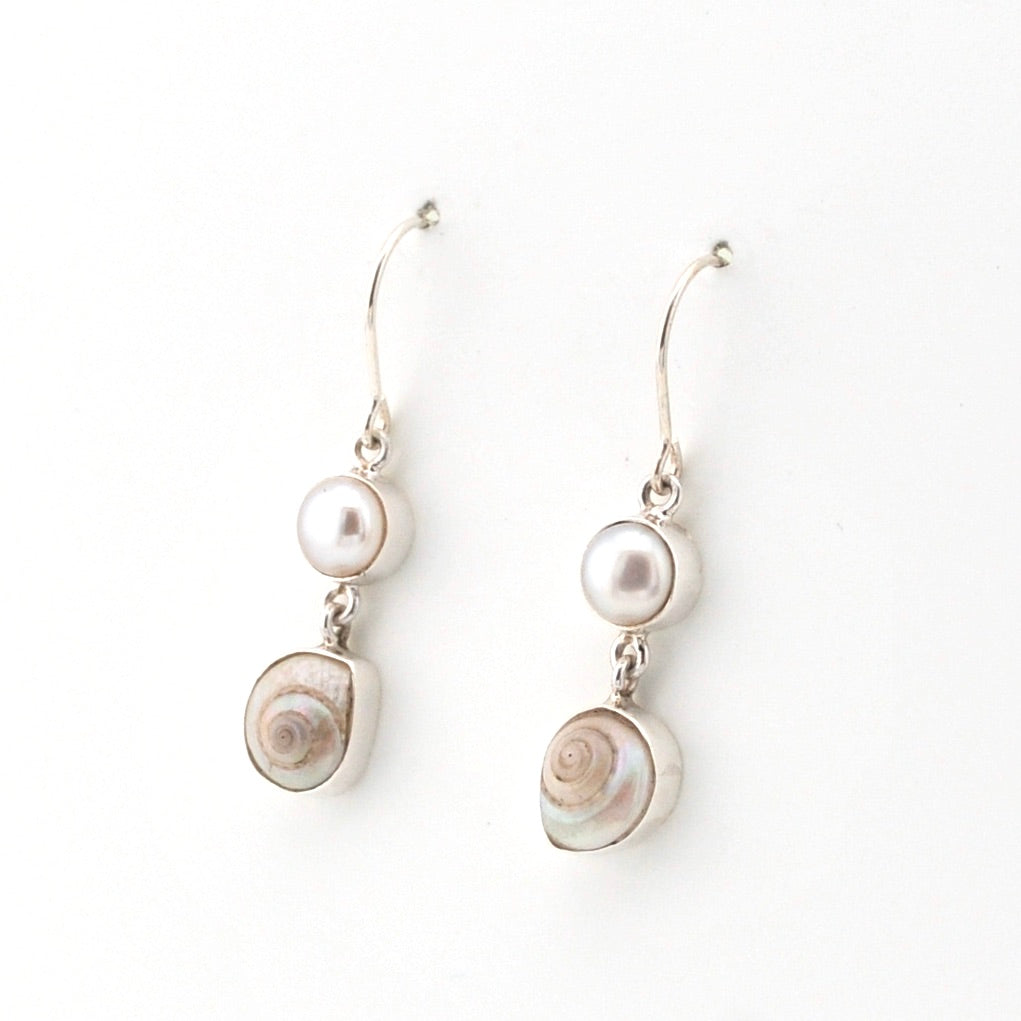 Pair of earrings with pearls and shell elements on a white background