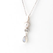 Necklace with pearl and teardrop-shaped pendant on a white background