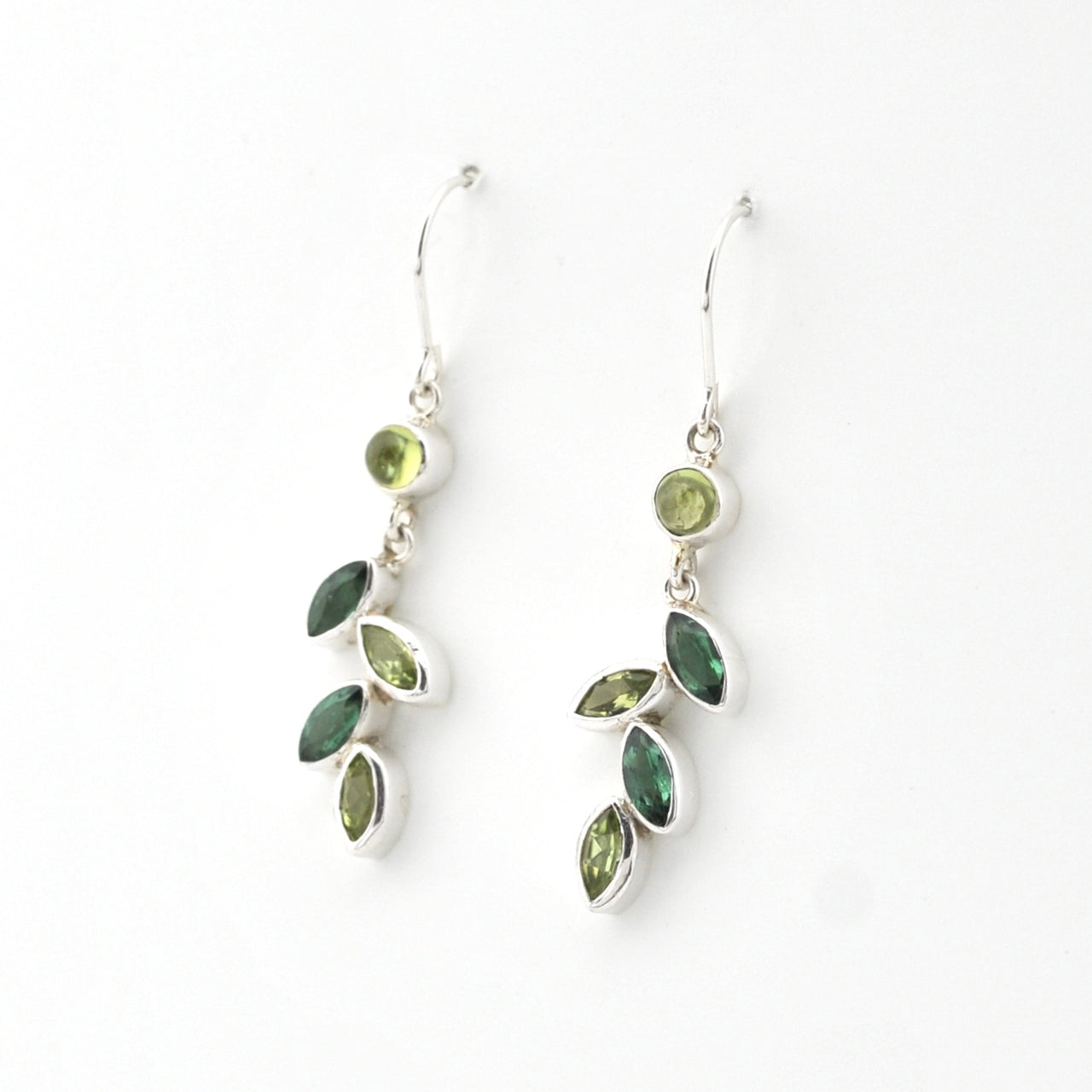Pair of silver earrings with green gemstones on a white background