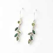 Pair of silver earrings with green gemstones on a white background