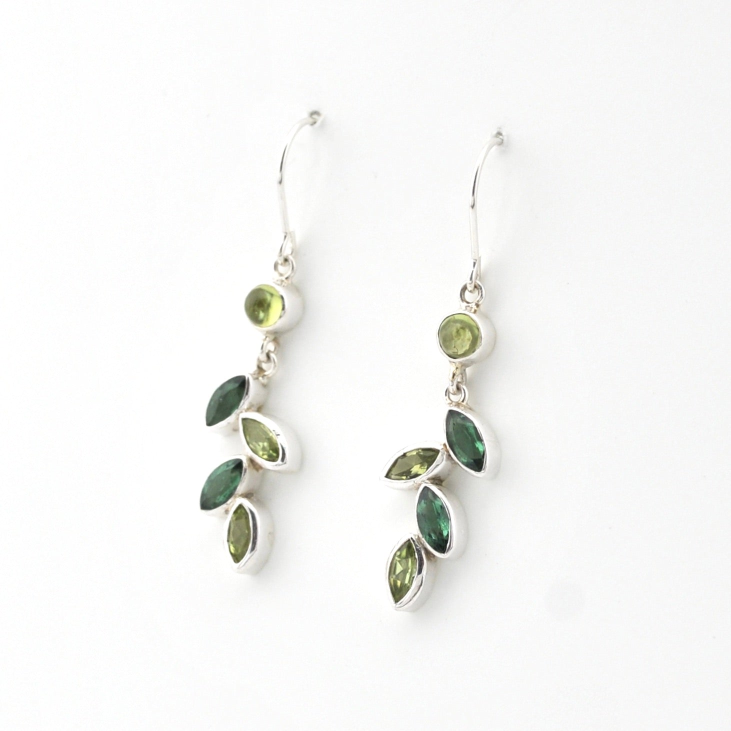 Pair of silver earrings with green gemstones on a white background