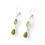 Pair of silver earrings with green gemstones on a white background