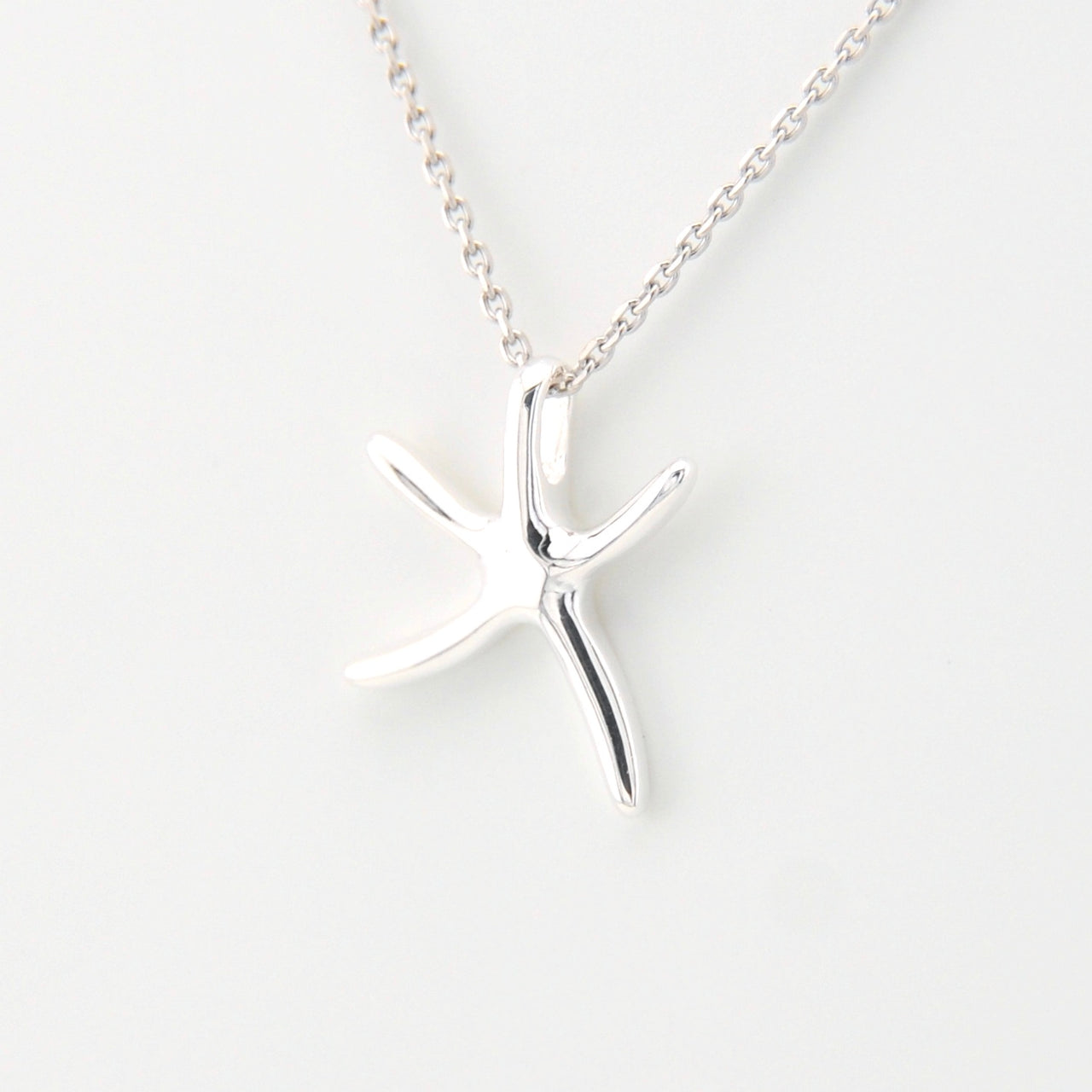 Silver starfish pendant necklace on a white background