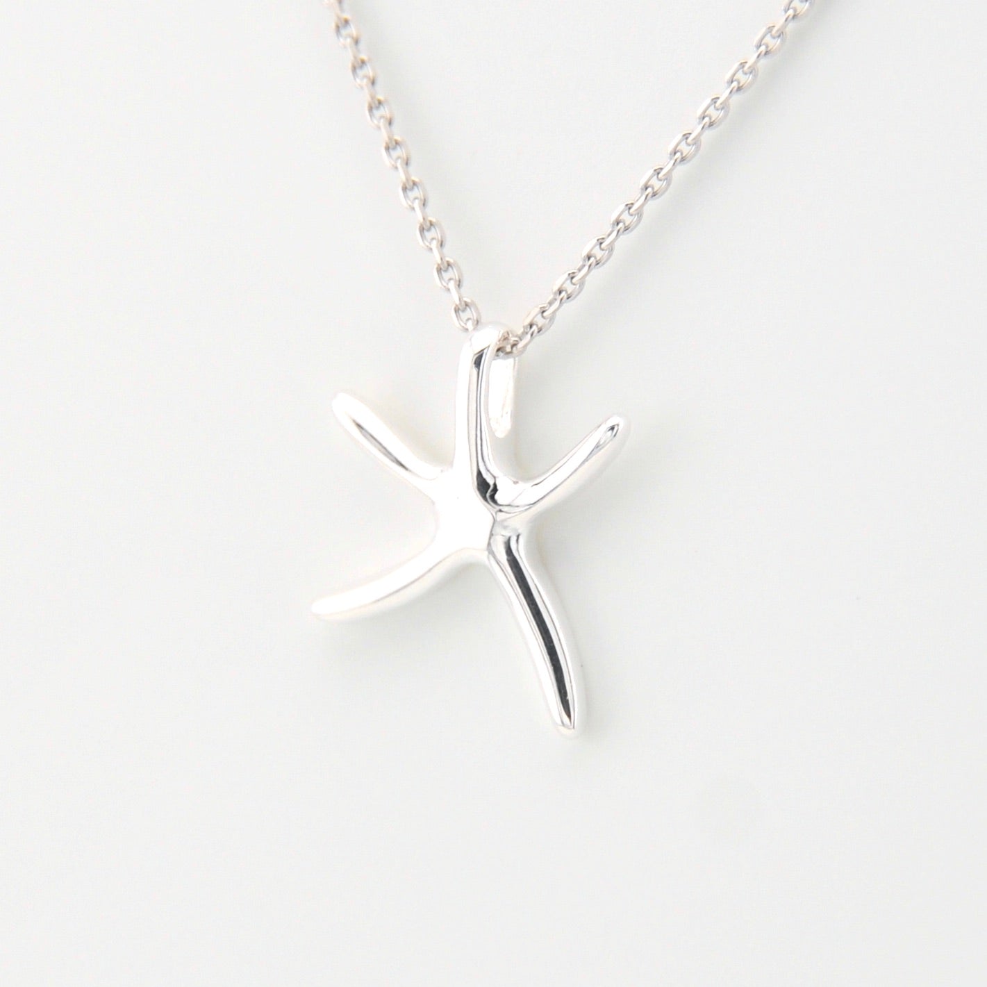 Silver starfish pendant necklace on a white background