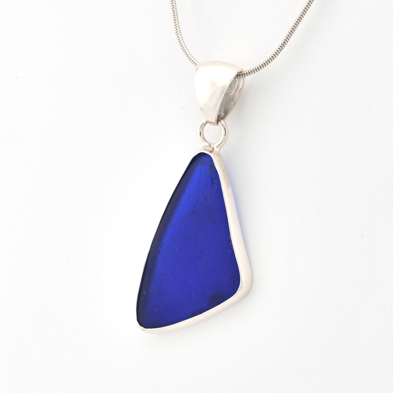 Blue sea glass pendant on a silver chain against a white background