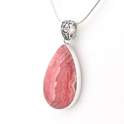 A teardrop-shaped pink stone pendant necklace set in a polished silver bezel with a silver chain, shown against a plain white background.