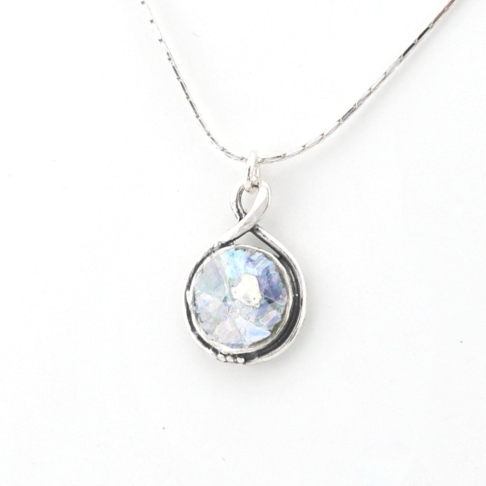 Silver necklace with a round pendant on a white background