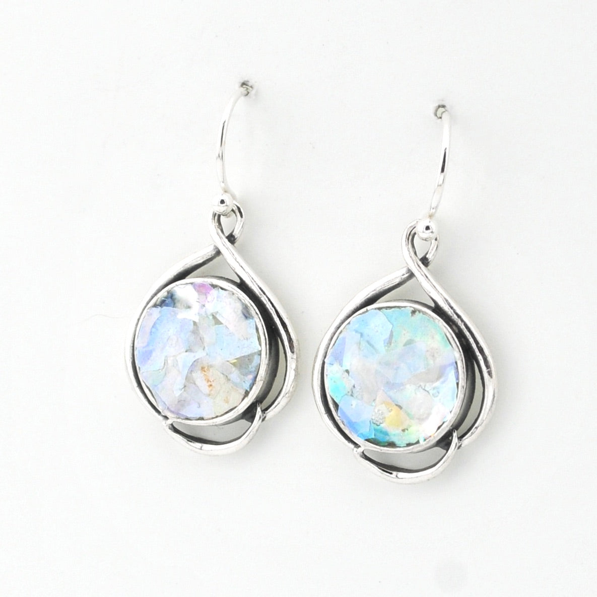 Silver earrings with round ancient glass on a white background