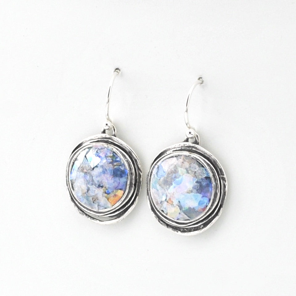 Silver earrings with round Roman glass on a white background