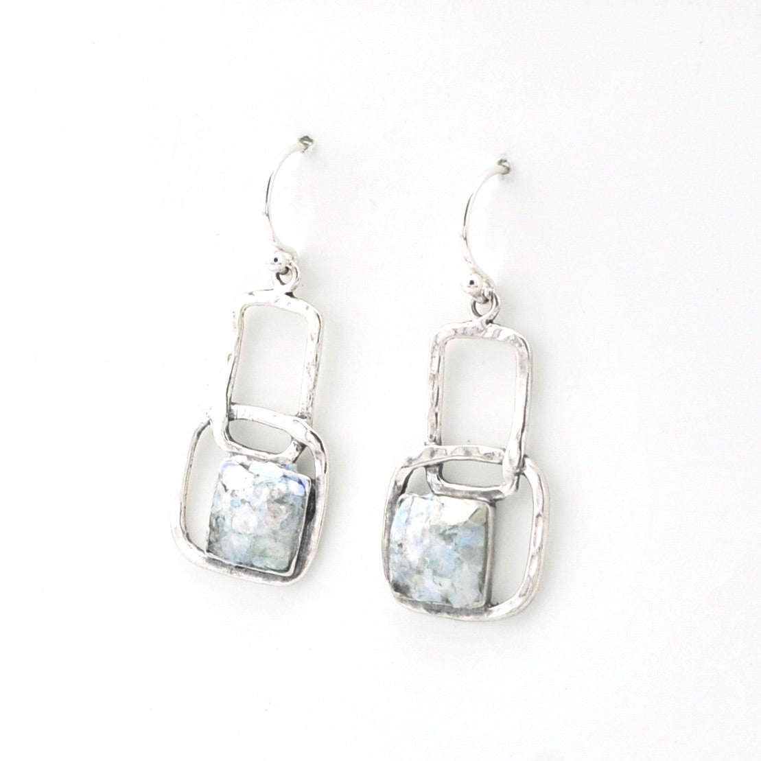 Silver earrings with clear gemstones on a white background