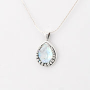 Teardrop-shaped pendant with Roman glass on a white background