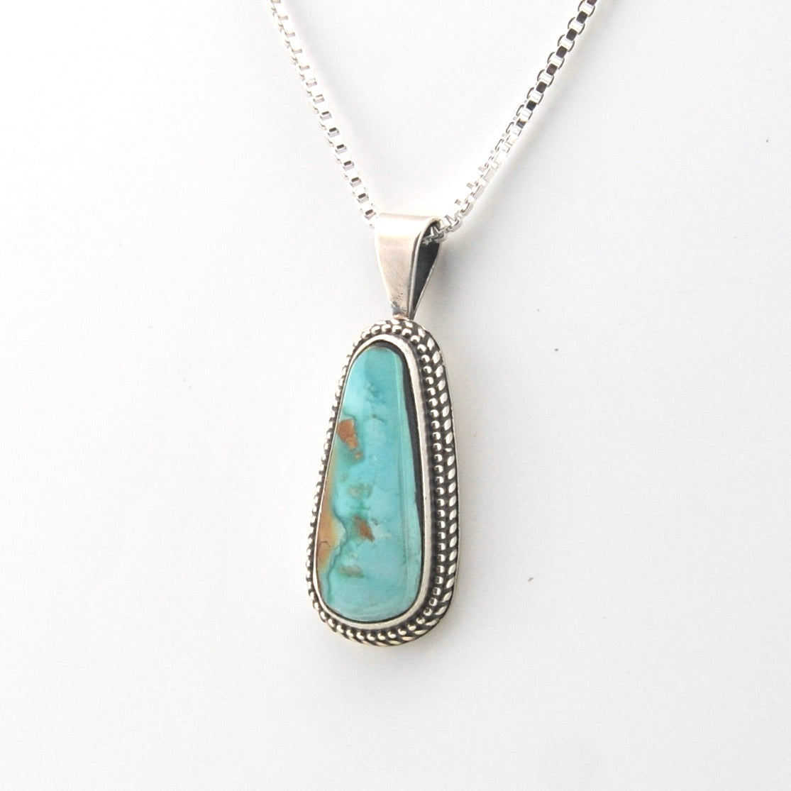 Turquoise pendant necklace on a white background