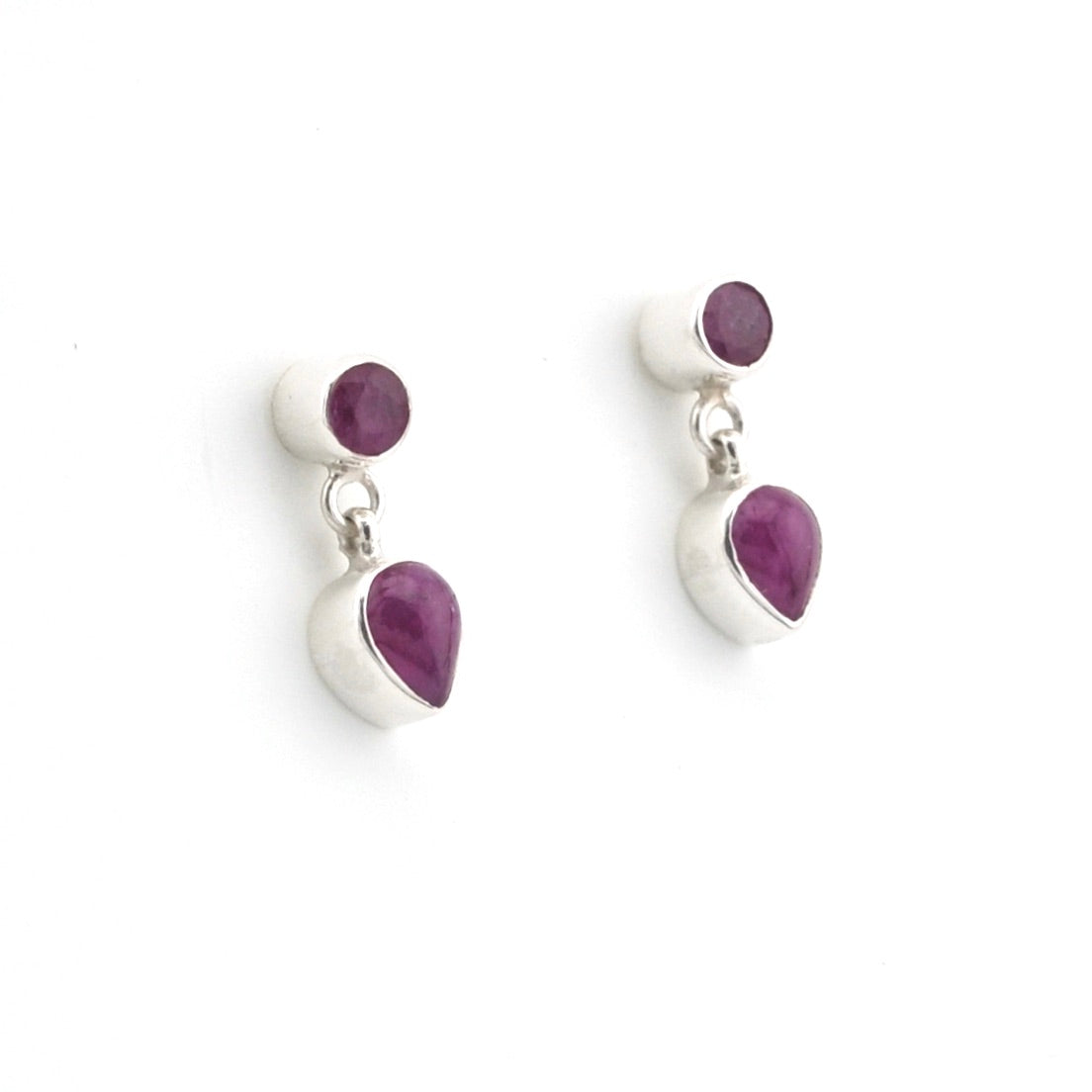Pair of silver earrings with purple gemstones on a white background