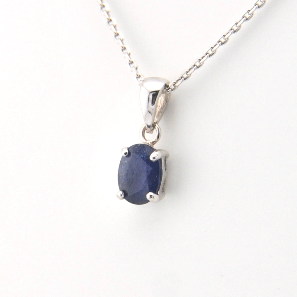 Silver pendant with a blue gemstone on a white background