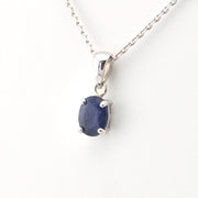 Silver pendant with a blue gemstone on a white background
