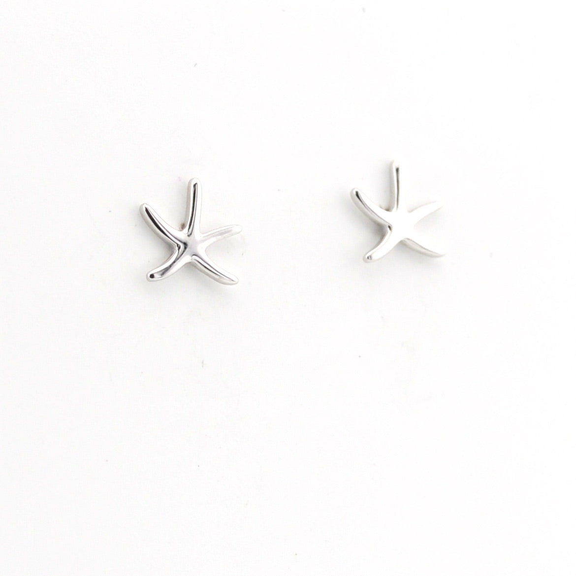Silver starfish-shaped earrings on a white background