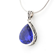 Teardrop-shaped blue gemstone pendant on a white background