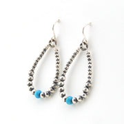 Pair of beaded earrings with blue accents on a white background