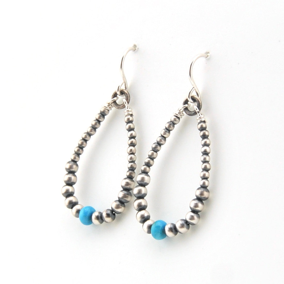 Pair of beaded earrings with blue accents on a white background