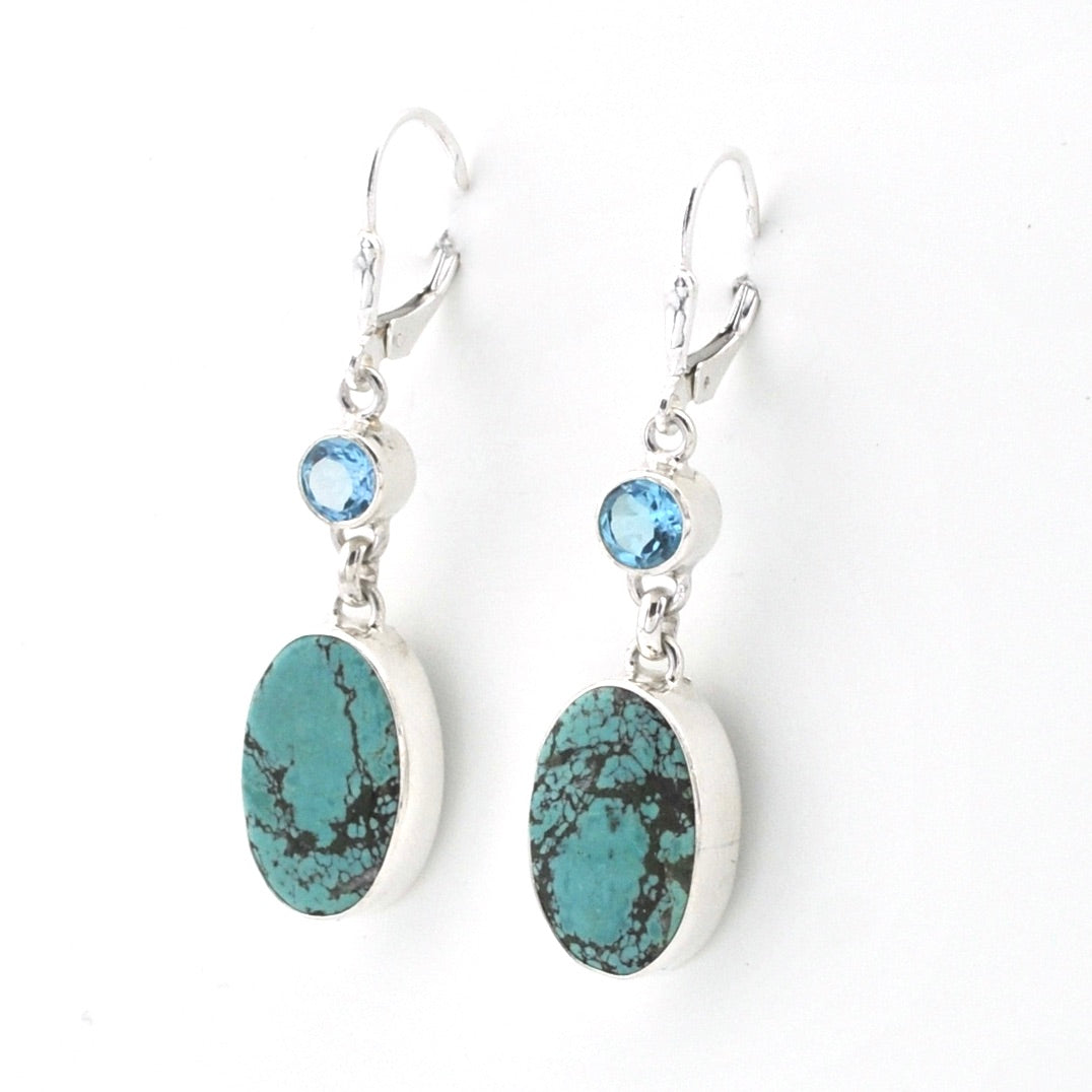 Pair of earrings with turquoise stones and blue gemstones on a white background