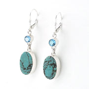 Pair of earrings with turquoise stones and blue gemstones on a white background