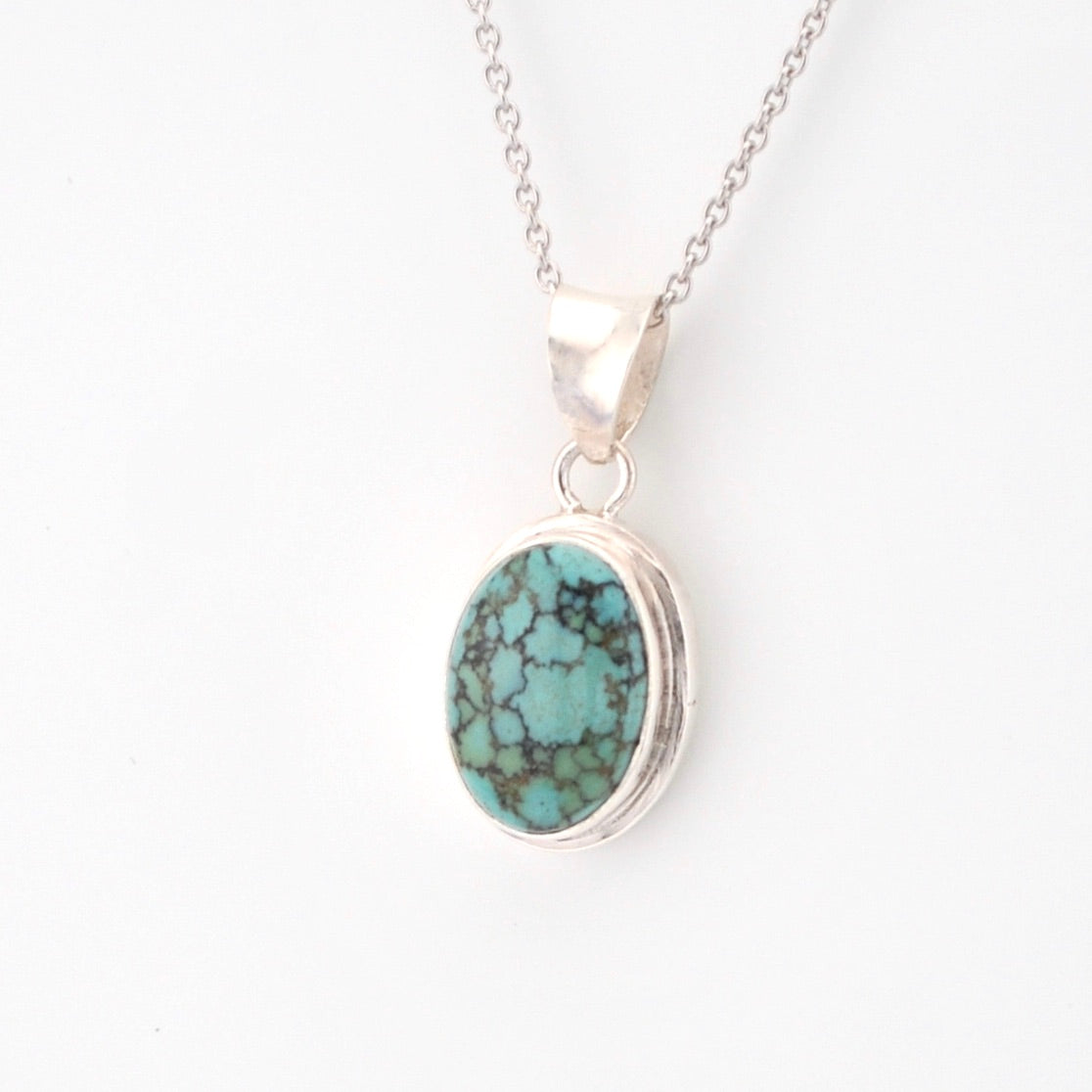 Turquoise pendant necklace on a white background