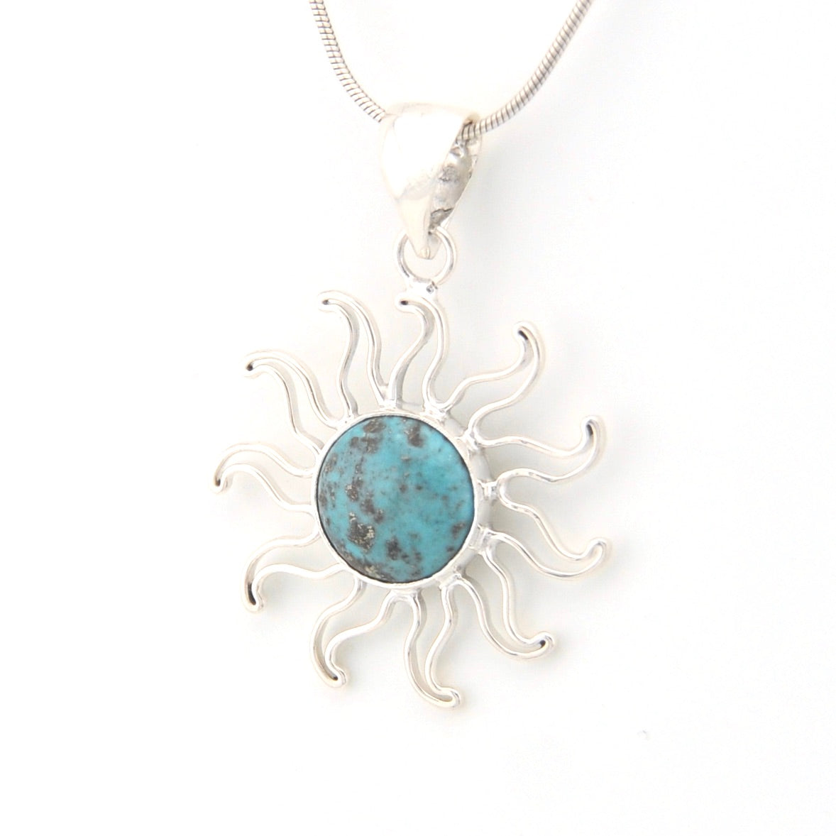 Silver sun-shaped pendant with a turquoise center on a white background