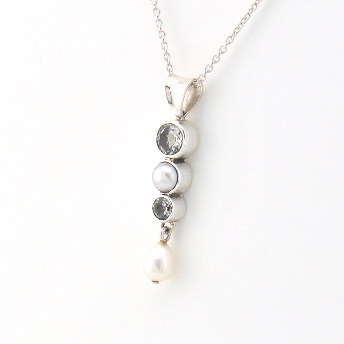 Necklace with pearl and gemstone pendant on a white background
