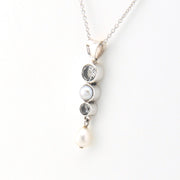 Necklace with pearl and gemstone pendant on a white background