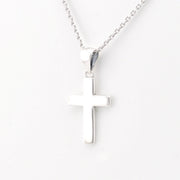 Silver cross necklace on a white background