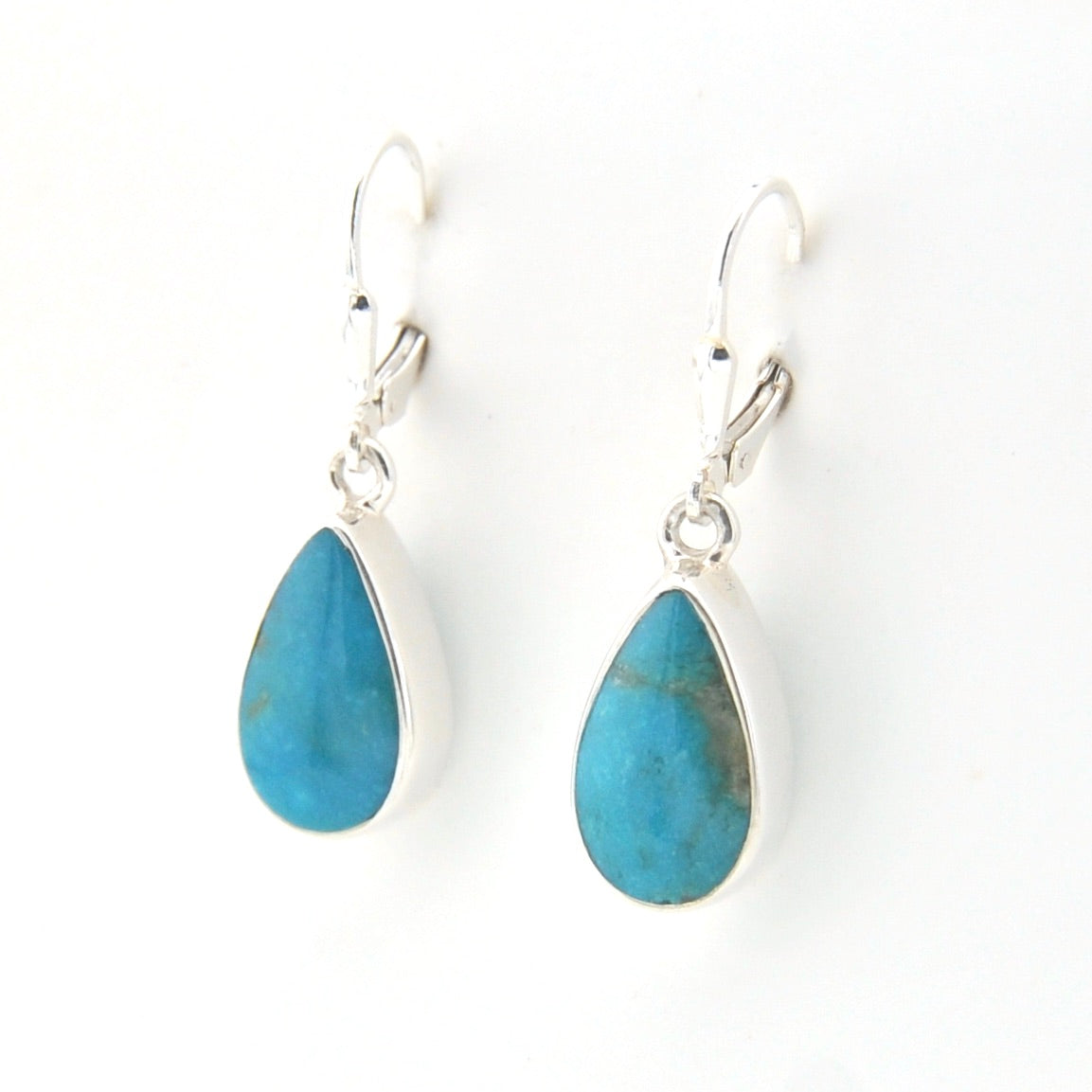 Teardrop-shaped blue stone earrings with silver hooks on a white background