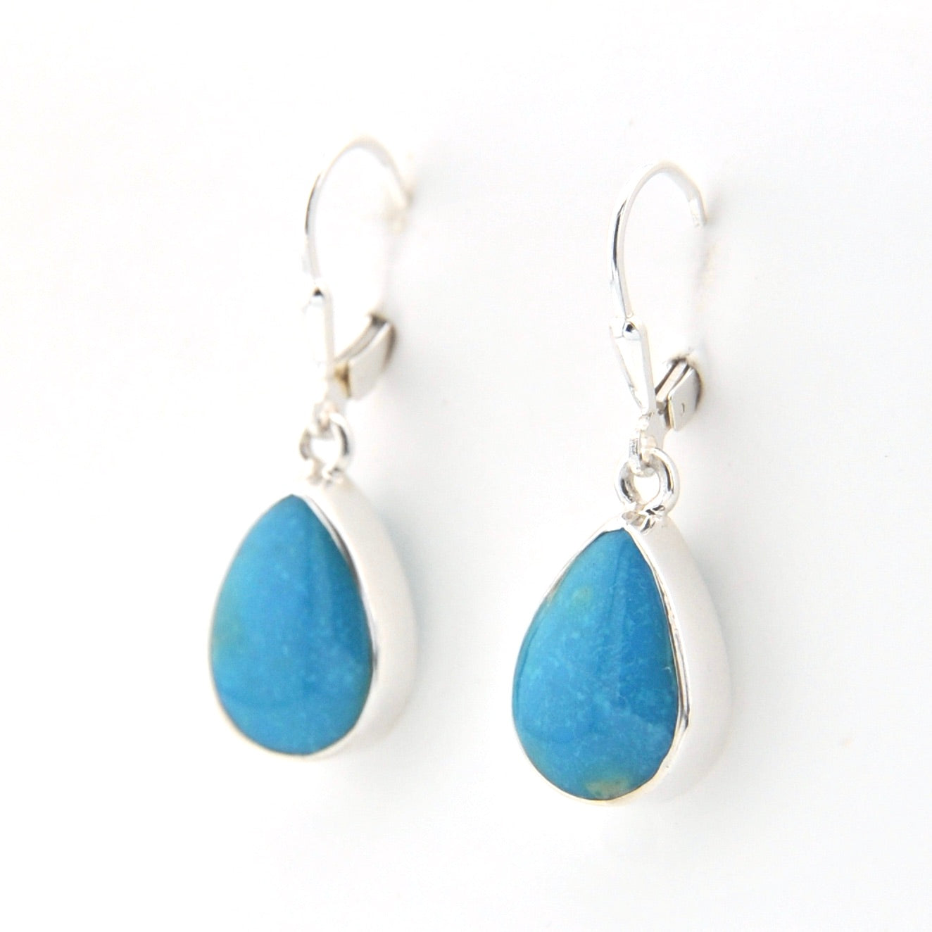 Teardrop-shaped blue earrings with silver hooks on a white background
