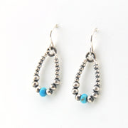 Pair of silver beaded earrings with blue beads on a white background