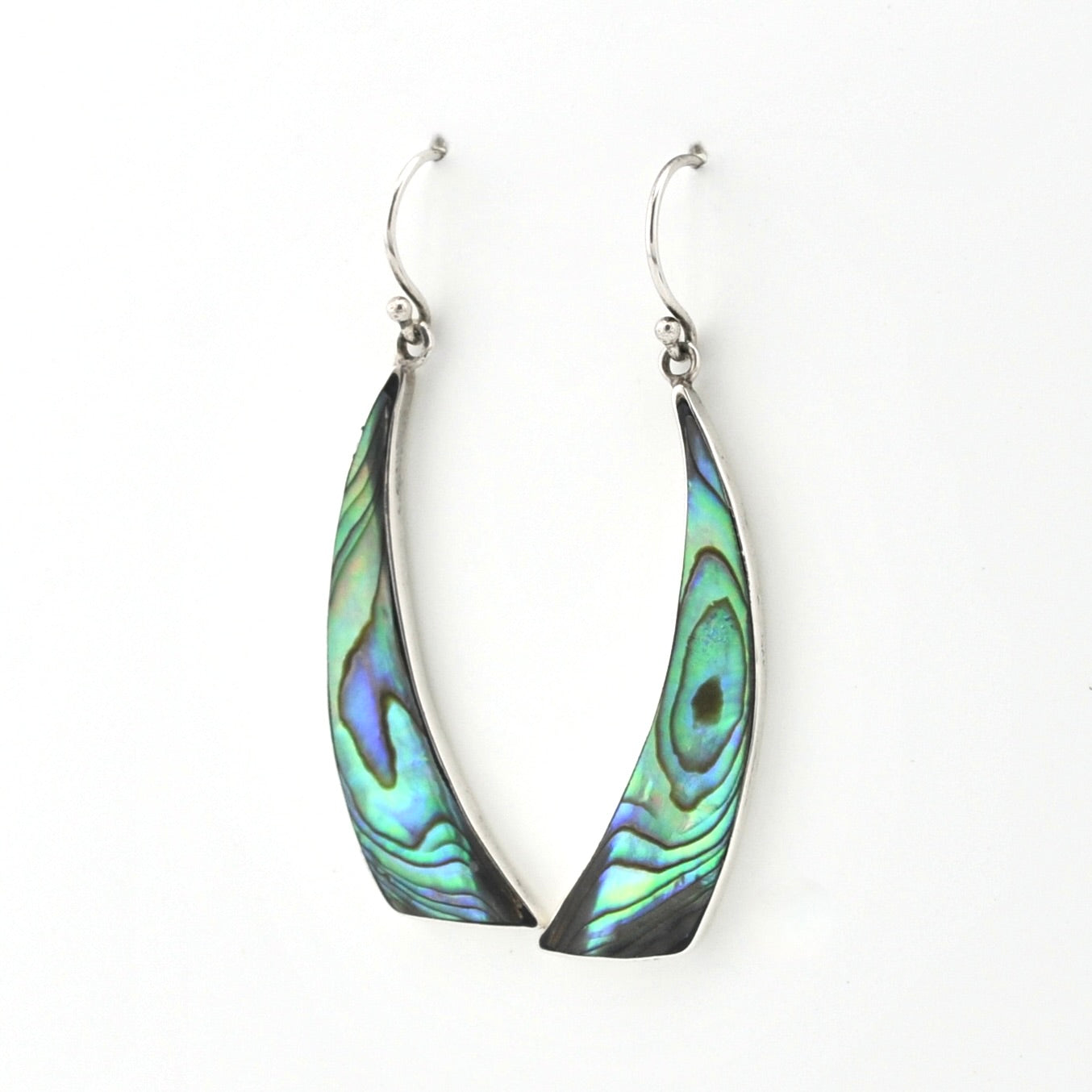 A pair of silver-toned dangle earrings with teardrop-shaped abalone shell inlays showing iridescent green, blue, and black patterns, set against a plain white background.