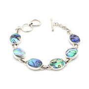 A silver-toned bracelet featuring six oval abalone shell inlays with iridescent blue, green, and purple patterns, displayed on a clean white background.