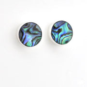 A pair of round stud earrings with iridescent abalone shell inlays on a silver-toned setting, shown against a plain white background.