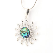 Silver sun-shaped pendant with abalone shell center on a white background