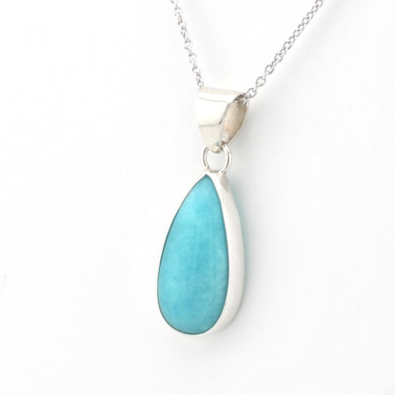 A silver teardrop pendant necklace featuring a smooth, polished light blue turquoise stone, shown on a clean white background.
