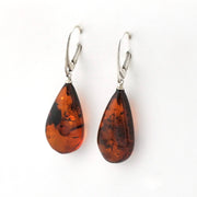 A pair of teardrop-shaped amber drop earrings with silver leverback hooks, displayed on a clean white background.