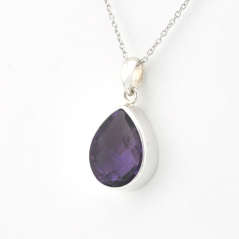 A silver pendant necklace featuring a teardrop-shaped purple gemstone, shown against a plain white background.