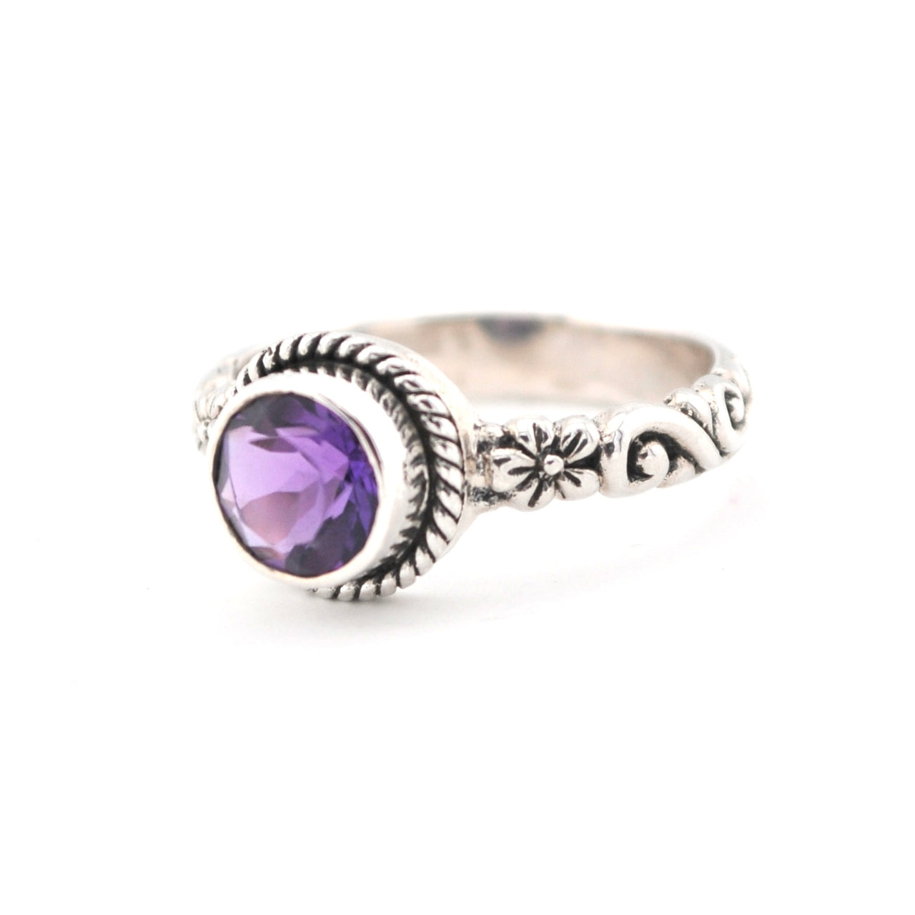 Silver ring with a purple gemstone on a white background