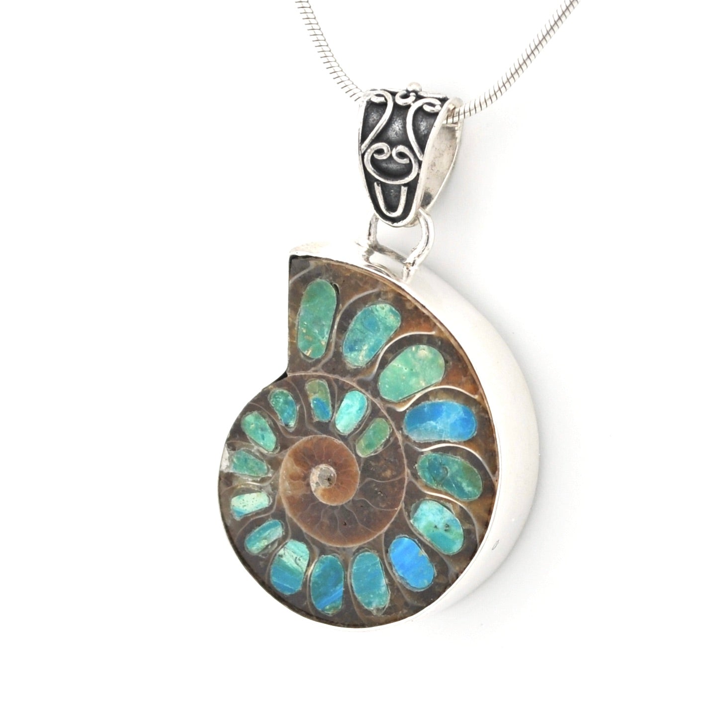 A silver pendant necklace featuring a polished ammonite shell inlay with iridescent blue, green natural opal, suspended from a silver chain on a white background.