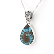 A teardrop-shaped pendant necklace featuring a natural brown and turquoise ammonite shell pattern set in a silver-tone bezel, suspended from a silver chain on a white background.