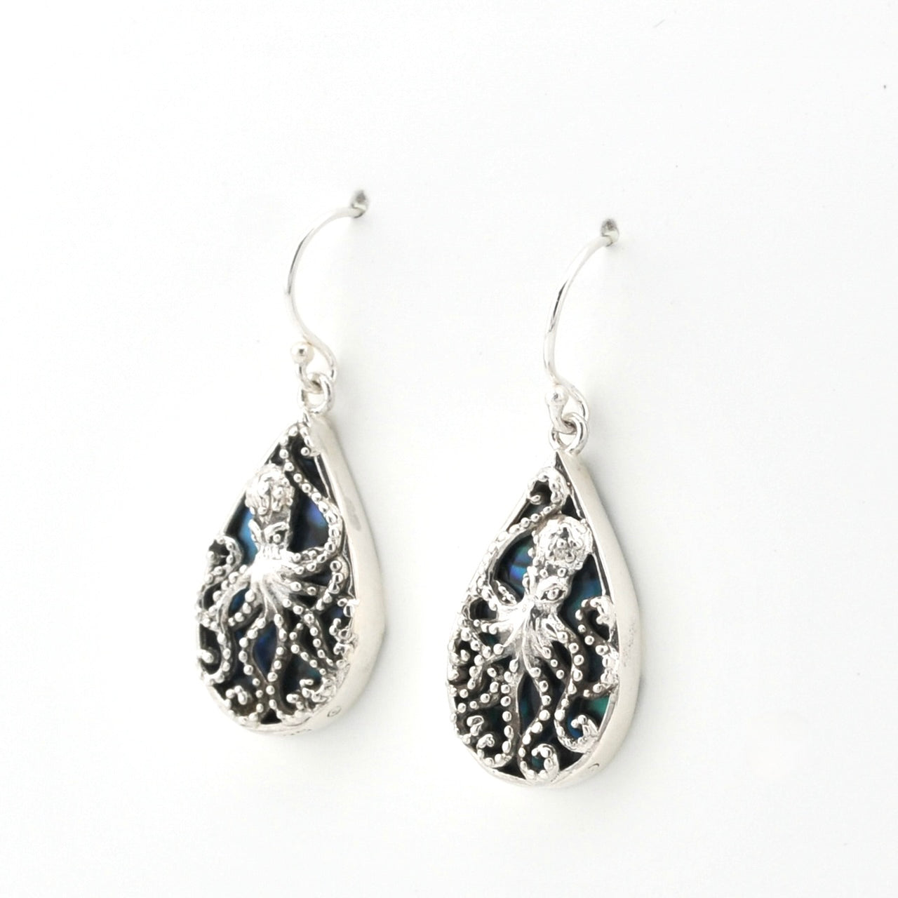 A pair of silver teardrop dangle earrings featuring intricate octopus filigree cutouts over dark iridescent inlay, shown on a plain white background.