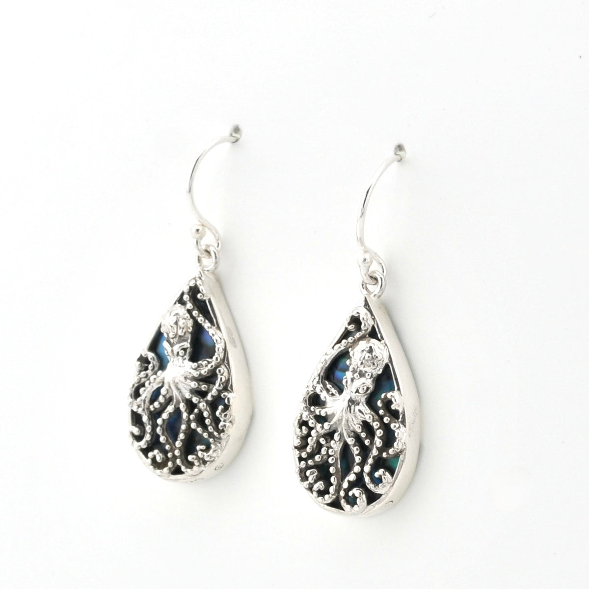 A pair of silver teardrop dangle earrings featuring intricate octopus filigree cutouts over dark iridescent inlay, shown on a plain white background.