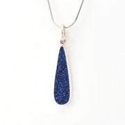 Teardrop-shaped blue pendant on a white background