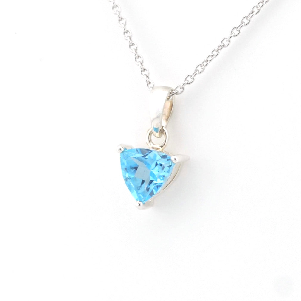 A silver necklace with a triangular light blue gemstone pendant, shown on a plain white background.