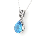 A silver pendant necklace featuring a teardrop-shaped light blue gemstone in an ornate silver setting, suspended from a delicate silver chain against a plain white background.