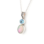 Silver necklace with a pendant featuring an opal and blue gemstone on a white background