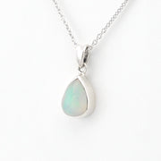 A silver teardrop pendant necklace featuring a smooth, iridescent white opal gemstone, shown on a delicate silver chain against a clean white background.